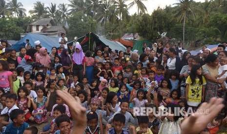 Sejumlah anak bernyanyi bersama dengan relawan di tempat penampungan pengungsi korban gempa bumi di Pemenang, Lombok Utara, Lombok Utara, NTB, Selasa (7/8). Sebanyak 2.935 jiwa korban gempa bumi mengungsi di tempat itu dan diperkirakan akan terus bertambah. 