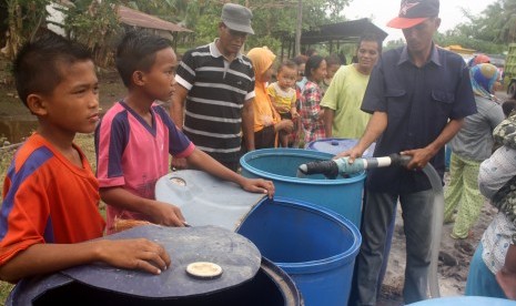 Sejumlah anak dan ibu-ibu dengan sabar antre pembagian air bersih, di Desa Rege Lestari Kecamatan Teluk Sampit Kabupaten Kotawaringin Timur, Kalteng, Minggu (4/10). 