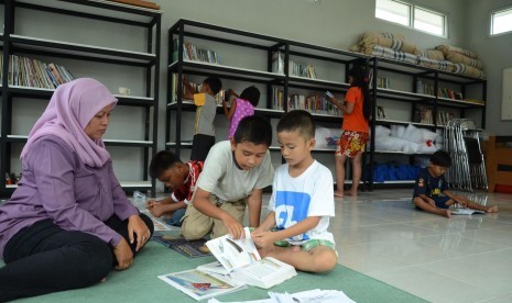  Sejumlah anak dari orang tua eks Gafatar membaca buku ditemani petugas di Perpustakaan Dinas Sosial Jabar, Kota Cimahi, Kota Bandung, Rabu (3/2).