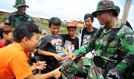 Sejumlah anak dari warga eks Gafatar bermain bersama anggota prajurit Yon 643 Wanara Sakti Anjungan, di pemukiman mereka di kawasan Monton Panjang, Dusun Pangsuma, Desa Antibar, Mempawah Timur, Kabupaten Mempawah, Kalbar, Selasa (19/1). 