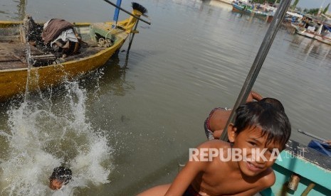 Sejumlah anak korban bongkaran pemukiman warga kawasan Pasar Ikan, bermain di pantai kawasan Penjaringan, Jakarta Utara, Jumat (15/4).  (Republika/ Raisan Al Farisi)