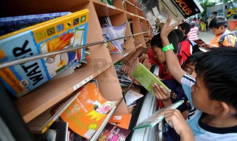  Sejumlah anak membaca buku di mobil perpustakaan keliling di Penjaringan, Jakarta Utara, Jumat (21/3). (Republika/Wihdan)