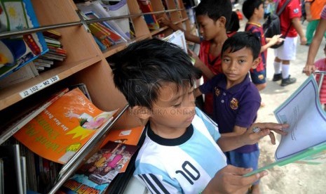  Sejumlah anak membaca buku di mobil perpustakaan keliling di Penjaringan, Jakarta Utara, Jumat (21/3). (Republika/Wihdan)