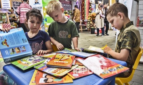 Sejumlah anak membaca buku di perpustakaan keliling pada acara Festival Literasi 2019 di Halaman Gedung Sate, Kota Bandung, Sabtu (20/4)