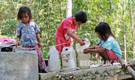 Sejumlah anak membantu orang tuanya mengumpulkan air bersih menggunakan jerigen di bak penampungan di kampung adat Prai Ijing, Desa Tebara, Waikabubak, Sumba Barat, Nusa Tenggara Timur.