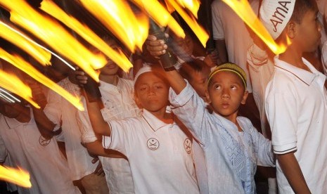 Sejumlah anak membawa obor dalam pawai malam Takbiran di Masjid Al Muhajirin, Kepaon, Denpasar, Bali, Rabu (7/8). (Antara/Nyoman Budhiana)