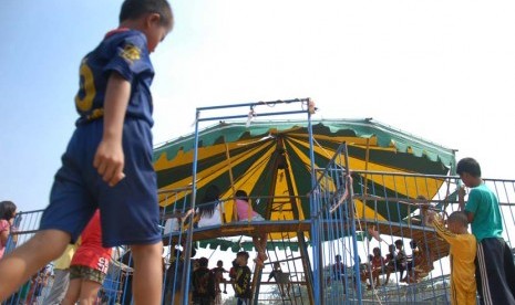 Sejumlah anak menaiki wahana bermain komedi putar di kawasan Pedongkelan,Jakarta Timur, Rabu (21/5)