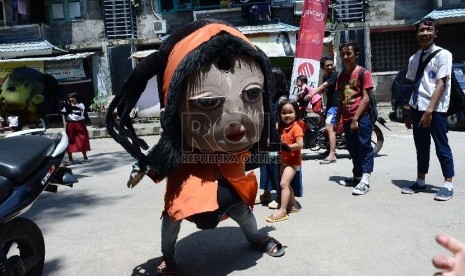 Sejumlah anak menonton boneka yang mengamen di Jalan Tambora, Jakarta Barat, Senin (9/3).  Polisi meringkus pengamen yang melakukan perampasan ponsel dan sekaligus mencekik Aldy (ilustrasi).