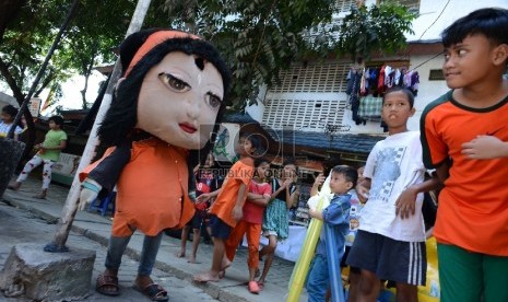 Sejumlah anak menonton pengamen boneka yang mengamen di Jalan Tambora, Jakarta Barat, Senin (9/3).   (Republika/Raisan Al Farisi)