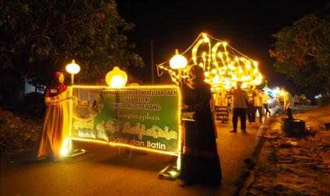 Sejumlah anak muda membawa lampion bertuliskan Asmaul Husna, dalam parade malam takbir menyambut Idul Fitri di esok harinya, di Bangka Tengah, Kepulauan Bangka Belitung, Indonesia Pada 14 Juni 2018. Parade membawa lampion merupakan tradisi yang dilakukan setiap tahu oleh warga Desa perlang, Bangka.