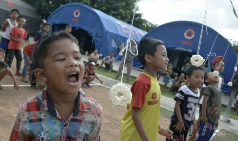 Sejumlah anak pengungsi Gunung Agung mengikuti lomba permainan tradisional di posko pengungsian GOR Swecapura, Klungkung, Bali, Minggu (15/10).