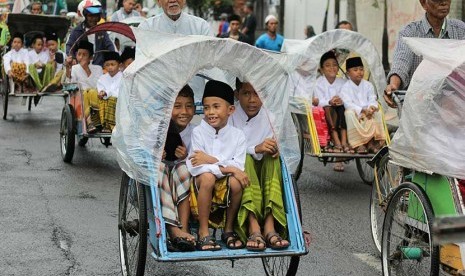 Sejumlah anak peserta khitan massal mengikuti pawai Maulid Nabi di kawasan Rangkah,  Surabaya, Jawa Timur, Senin (12/12). 