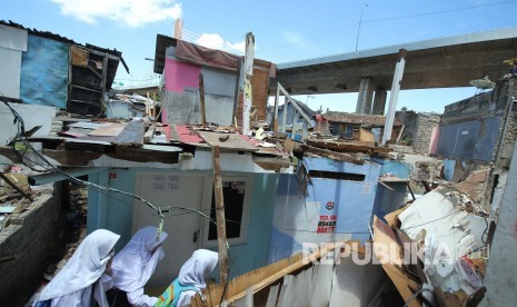 Sejumlah anak sekolah melewati rumah-rumah yang dibongkar sendiri oleh pemiliknya di lokasi proyek pembangunan Rumah Deret Tamansari, Kota Bandung 