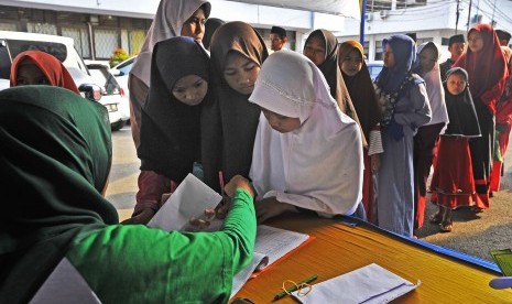 Sejumlah anak yatim menerima santunan dari petugas Baznas (Badan Amil Zakat Nasional). 