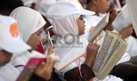  Sejumlah anak yatim mengikuti Khataman Alquran yang diadakan oleh Rumah Zakat di Monumen Nasional (Monas) Jakarta, Ahad (7/7).  (Republika/Agung Supriyanto)