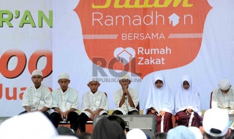  Sejumlah anak yatim mengikuti Khataman Alquran yang diadakan oleh Rumah Zakat di Monumen Nasional (Monas) Jakarta, Ahad (7/7).  (Republika/Agung Supriyanto)