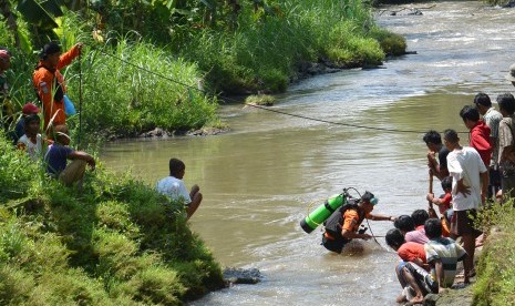 Sejumlah anggota Badan SAR Nasional (Basarnas) melakukan pencarian seorang relawan Badan Penanggulangan Bencana Daerah (BPBD) yang hilang dengan cara menyelam di Sungai Suren, Desa Pakusari, Jember, Jawa Timur, Kamis (24/11).