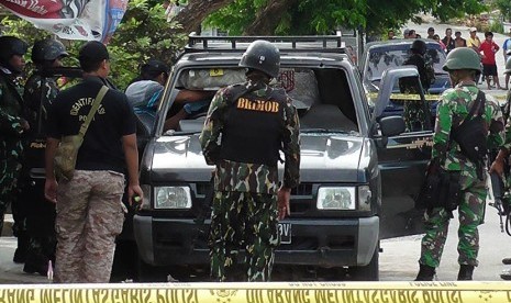 Sejumlah anggota Brimob berjaga disekitar mobil ketika olah tempat kejadian perkara (TKP) baku tembak antara Polisi dengan kelompok sipil bersenjata  di Sanginora, Poso Pesisir, Sulawesi Tengah, Selasa (9/2). 