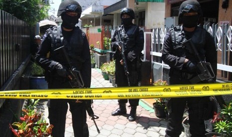 Sejumlah anggota Brimob Polda Jatim bersenjata lengkap melakukan penjagaan saat rumah milik terduga anggota Negara Islam Suriah dan Irak (ISIS) berinisial HM digeledah di Jalan Ade Irma Suryani, Malang, Jawa Timur, Kamis (26/3). 