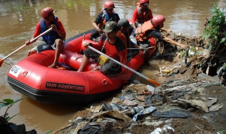   Sejumlah anggota dan masyarakat peduli Ciliwung menaiki perahu karet untuk memunguti sampah di bantaran Kali Ciliwung. Ilustrasi