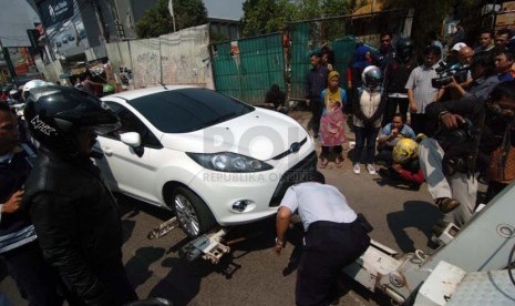 Sejumlah Anggota dari Dinas Perhubungan melakukan razia kepada pengendara mobil yang parkir sembarangan di kawasan Pondok Labu, Jakarta Selatan, Selasa (23/9).(Republika/Raisan Al Farisi)