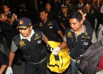 Sejumlah anggota kepolisian mengevakuasi jenazah tersangka pelaku bom bunuh diri di Gereja GBIS Kepunton, Solo, Minggu (25/9). 