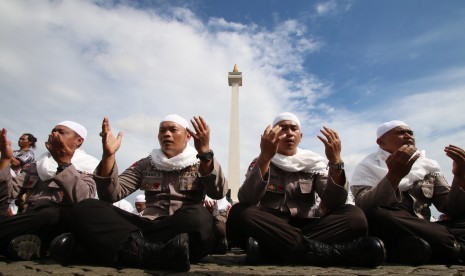 Sejumlah anggota kepolisian yang sekaligus pasukan Asmaul Husna berdoa saat mengikuti apel gelar pasukan pengamanan aksi bela Islam jilid III (212) di Monas, Jakarta, Kamis (1/12). 