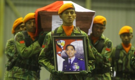 Sejumlah anggota Paskhas TNI AU membawa peti jenazah pilot pesawat Hercules C-130 Kapten Penerbang Sandy Permana saat tiba di Hanggar Skuadron 32, Lanud Abdul Rahman Saleh, Malang, Jawa Timur, Rabu (1/7) malam.