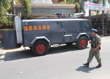 Sejumlah anggota polisi bersenjata lengkap, berjaga di sekitar lokasi peristiwa bom bunuh diri di Gereja GBIS Kepunton, Solo, Jateng, Ahad (25/9).