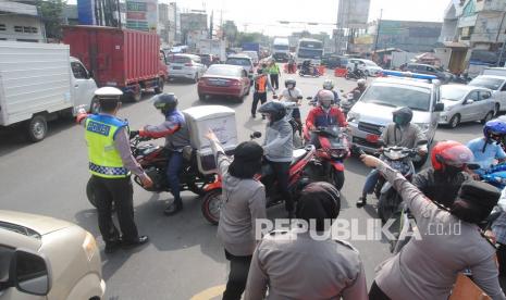 Sejumlah anggota Polresta Bogor Kota mengarahkan pengendara motor untuk melalui jalan alternatif saat penyekatan kendaraan di Simpang Pomad, Kota Bogor, Jawa Barat, Rabu (7/7/2021). Polresta Bogor Kota memperluas dan memperketat pelaksanaan penyekatan kendaraan bermotor dengan menambah enam lokasi penyekatan di batas kota selama PPKM Darurat sebagai upaya menekan mobilitas warga.