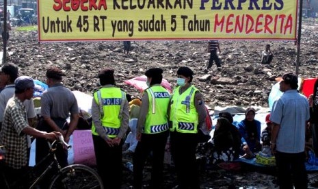 Sejumlah anggota Samapta Polres Sidoarjo, di antara warga korban luapan lumpur panas Lapindo yang mengikuti doa bersama di lokasi bekas Pasar Porong Lama, Sidoarjo, Rabu (16/2). Doa bersama yang diikuti ratusan warga korban luapan lumpur dari 45 RT dalam t