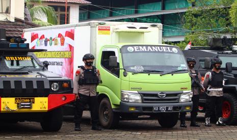 Sejumlah anggota Sat Brimob Polda Kalimantan Barat berjaga di samping truk yang membawa vaksin COVID-19 Sinovac saat pelepasan di Dinas Kesehatan di Pontianak, Kalimantan Barat, Rabu (13/1/2021). Dinas Kesehatan Kalimantan Barat mulai mendistribusikan 15.880 dosis vaksin COVID-19 Sinovac ke tiga kabupaten/kota yaitu Pontianak, Kubu Raya dan Mempawah.