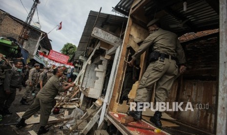 Sejumlah anggota satpol pp melakukan penggusuran di pemukiman yang terkena proyek normalisasi Sungai Ciliwung, Bukit Duri, Jakarta, Rabu (28/9)