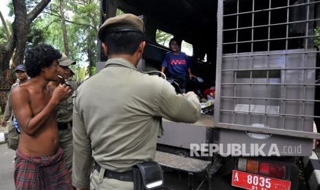 Sejumlah anggota Satpol PP Pemprov Banten mengamankan orang gila yang berkeliaran di Alun-alun Kota Serang, di Serang, Banten, Selasa (20/2). 