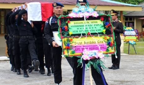 Sejumlah anggota Satuan Brimob Batalyon B Pelopor Polda Papua menandu peti yang berisi jenazah Briptu Berry Permana Putra, di Markas Komando Satuan Brimob Batalyon B Pelopor, Mimika, Papua, Senin (23/10). 