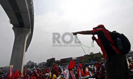   Sejumlah anggota Serikat Buruh Pelabuhan melakukan aksi dengan menutup akses masuk Pelabuhan Tanjung Priok, Jakarta Utara, Kamis (31/10).  (Republika/Adhi Wicaksono)