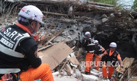 Sejumlah anggota Tim SAR Korea Selatan berusaha mengevakuasi korban gempa bumi yang tertimbun reruntuhan gedung Restoran Dunia Baru di Palu, Sulawesi Tengah, Senin (22/10/2018).