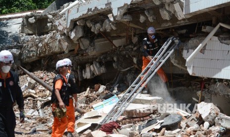 Sejumlah anggota Tim SAR Korea Selatan berusaha mengevakuasi korban gempa bumi yang tertimbun reruntuhan gedung Restoran Dunia Baru di Palu, Sulawesi Tengah, Senin (22/10/2018). 