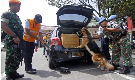 Sejumlah anggota TNI AU memeriksa mobil yang masuk menggunakan anjing pelacak bahan peledak di Bandara Adi Sutjipto Yogyakarta, Jumat (22/1). 