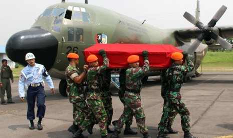 Sejumlah anggota TNI AU mengangkat peti yang berisikan jenasah dari korban pesawat pesawat Hercules C-130 saat proses pengembalian jenazah korban di Lanud Soewondo Medan, Sumatera Utara, Rabu (1/7).