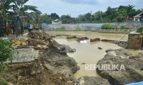 Sejumlah anggota TNI dan warga menyaksikan tanggul bendungan Gelapan yang jebol di Desa Gelapan, Gubug, Grobogan, Jawa Tengah, Kamis (9/1/2020). J