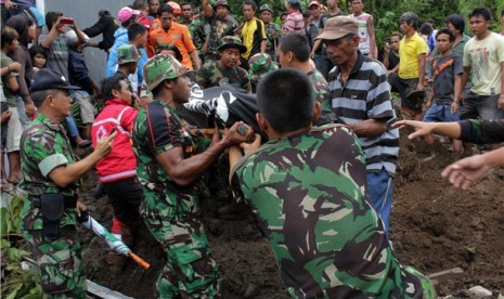  Sejumlah anggota TNI dibantu warga mengevakuasi korban tanah longsor di kawasan Citraland, kota Manado, Sulawesi Utara, Minggu (17/2). 