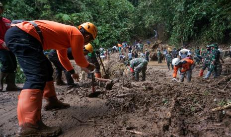 Sejumlah anggota TNI Kodim 0710 Pekalongan bersama petugas Badan Penanggulangan Bencana Daerah (BPBD) dan relawan membersihkan material longsor tanah yang menutupi jalan di Dukuh Tinalum, Kayupuring, Kecamatan Petungkriyono, Kabupaten Pekalongan, Jawa Tengah, Rabu (19/1/2022). Berdasarkan data Badan Penanggulangan Bencana Daerah (BPBD) setempat, sebanyak tiga titik di Dukuh Tinalum mengalami longsor tanah akibat hujan deras pada Selasa (18/1/2022) yang berimbas jalan alternatif menuju Banjarnegara terputus. 