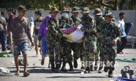 Sejumlah anggota TNI mengangkat jenazah korban gempa bumi menuju mobil ambulans di halaman Rumah Sakit Umum Daerah Kabupaten Lombok Utara di Tanjung, Lombok Utara, NTB, Senin (6/8).