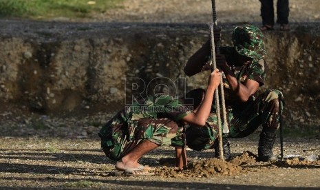 Sejumlah anggota TNI mengerjakan pembangunan pondasi untuk pembangunan Mushalla di Tolikara, Papua, Jumat (24/7).   (Republika/Raisan Al Farisi)