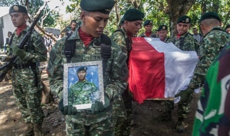 Sejumlah anggota TNI mengusung peti jenazah Pratu Ibnu Hidayat saat prosesi pemakaman di Tempat Pemakaman Umum Dongko di Desa Kebonbatur, Demak, Jawa Tengah, Kamis (18/5). 