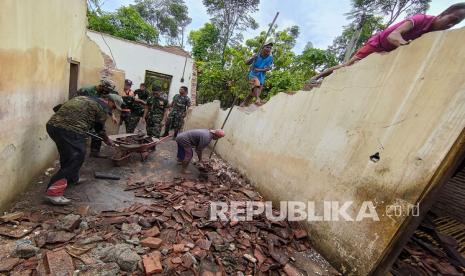 Sejumlah anggota TNI/Polri bersama relawan bergotong royong mengevakuasi perabot dari dalam rumah warga yang ambruk terdampak gempa di Trenggalek, Jawa Timur, Ahad (11/4/2021). Tercatat sebanyak 63 bangunan di 27 desa 11 kecamatan di daerah tersebut rusak terdampak gempa bermagnitudo 6,7 di Kabupaten Malang.