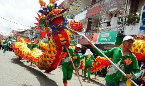 Sejumlah anggota Yayasan Tionghoa Pemadam Kebakaran Merdeka memainkan atraksi naga, sesaat sebelum menjalani ritual Naga Tutup Mata di Kelenteng Kwan Tie Bio, Pontianak, Kalbar