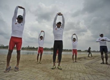 Sejumlah atlet dayung Indonesia melakukan pemanasan sebelum berlatih di Arena Dayung SEA Games XXVI di Cipule, Karawang, Jawa Barat, Selasa (8/11). 