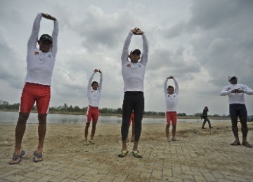 Sejumlah atlet dayung Indonesia melakukan pemanasan sebelum berlatih di Arena Dayung SEA Games XXVI di Danau Cipule, Karawang, Jawa Barat.